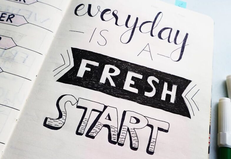 Notebook page featuring motivational quote 'Everyday is a fresh start' with colorful pens.